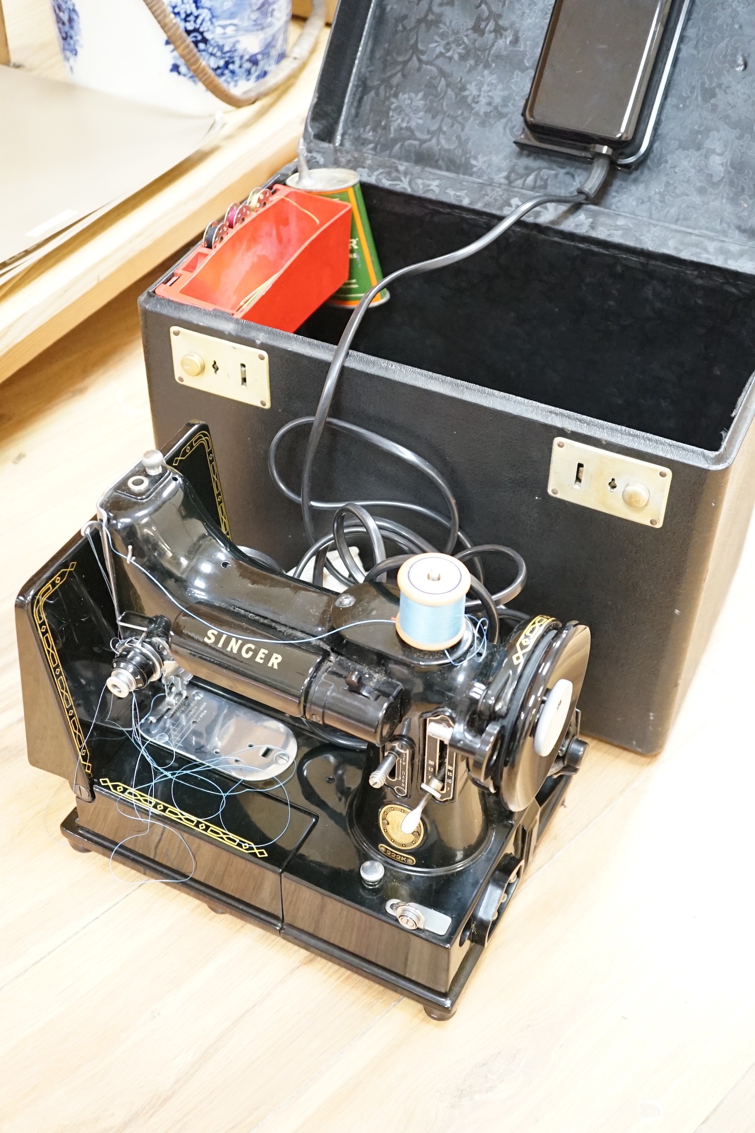 A cased portable Singer Featherweight 222K sewing machine with accessories